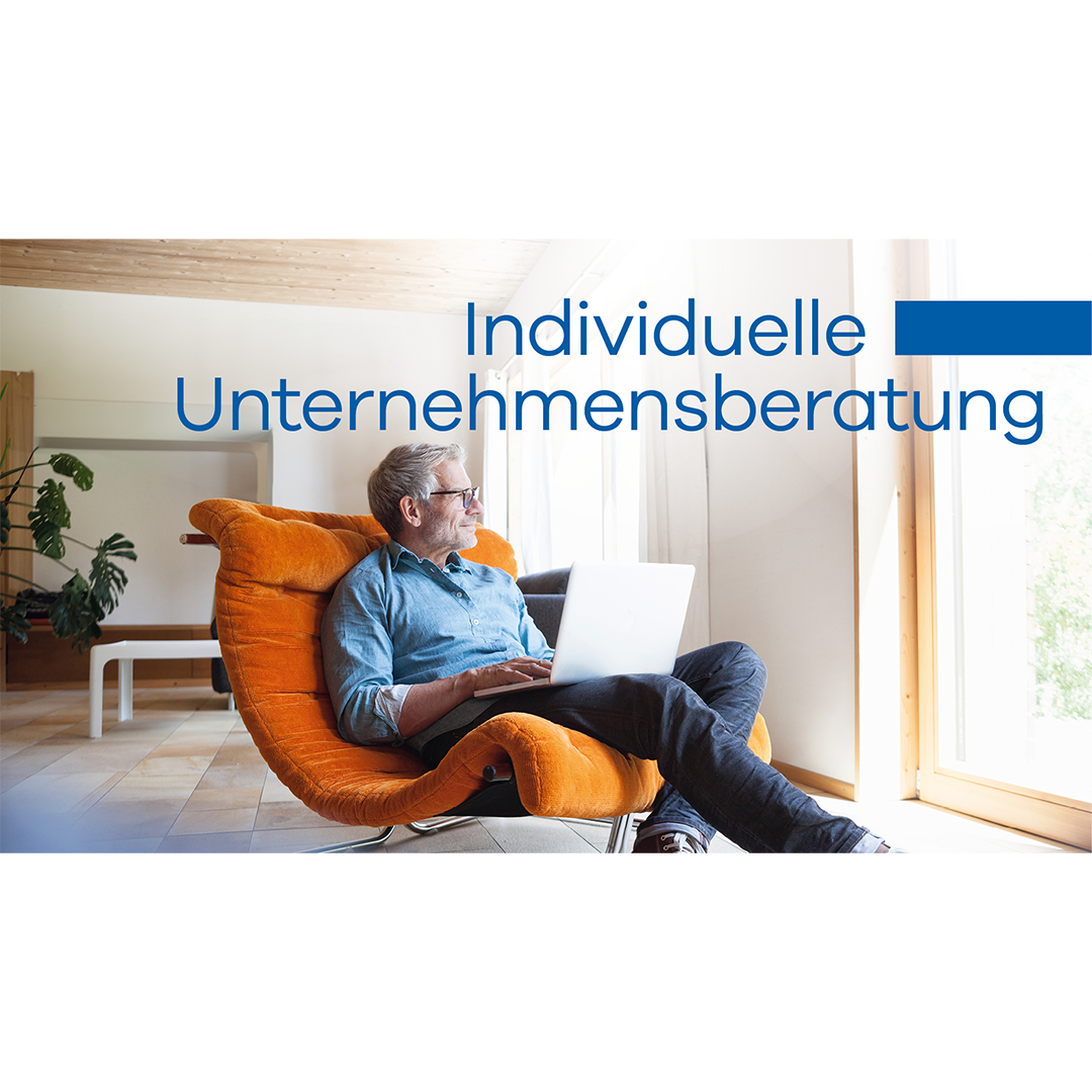 Mann sitzt im Sessel mit Laptop