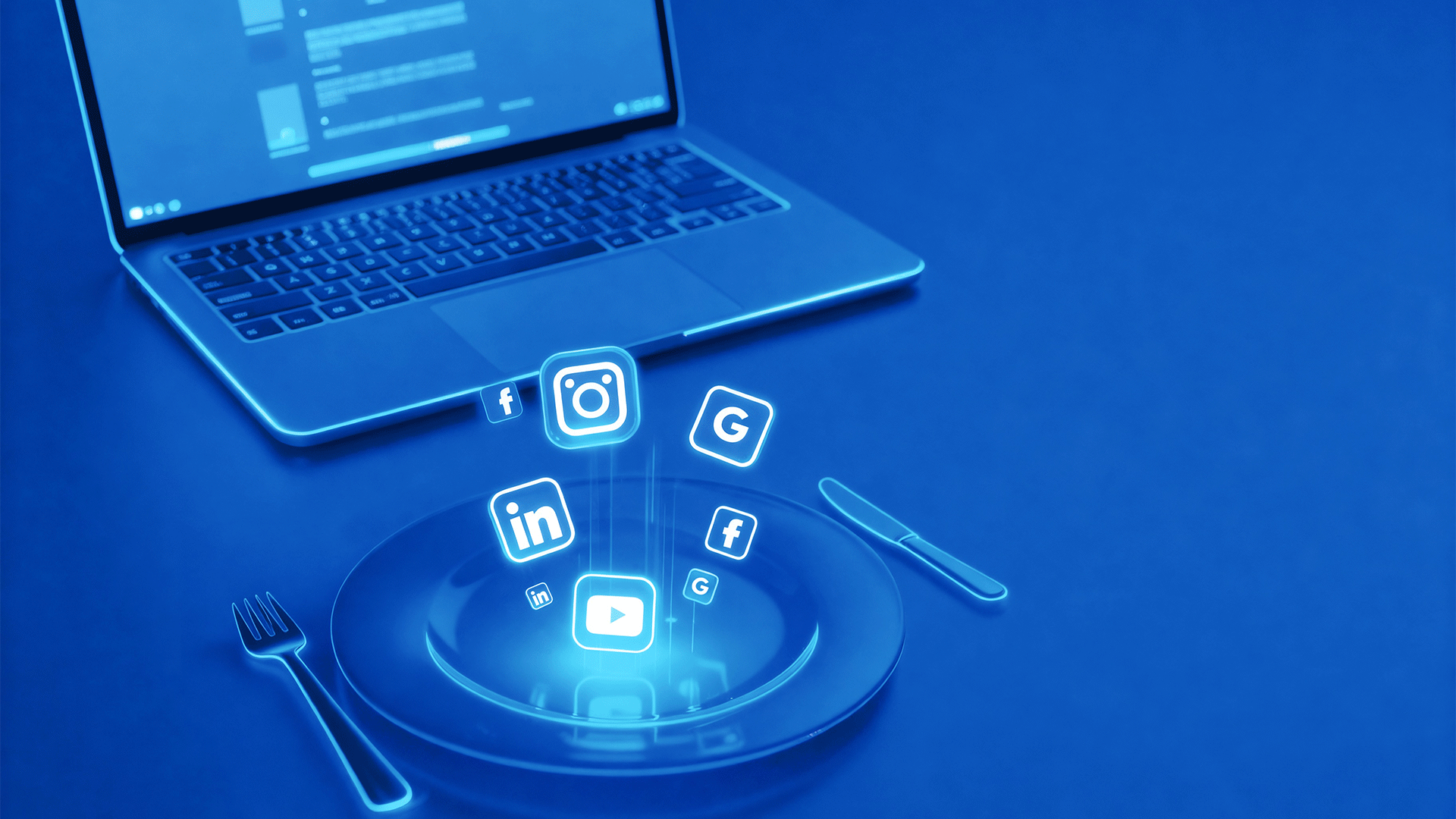 Laptop mit Teller und Besteck