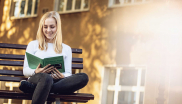 Frau liest auf einer Bank das Buch: Trockenes Auge Akademie Summerschool